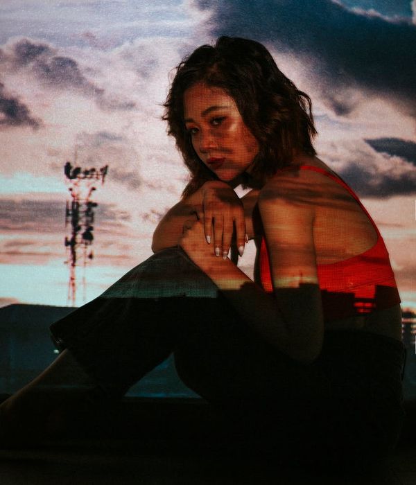 Woman in a dynamic cardio pose against a dark background.